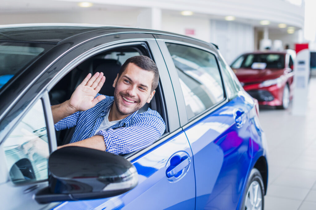 a man sitting in car showing hand